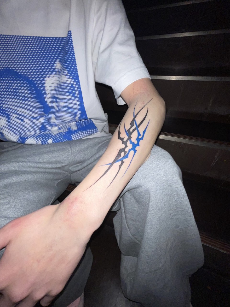 Neo tribal blackwork in black and blue on a forearm
